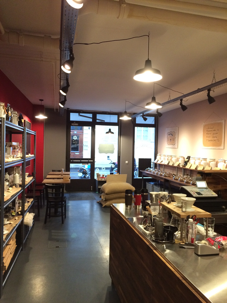 Une vue d'intérieur du coffee shop Valmandin. Les utensils, les machines à café, les filtres à café et autres sont visibles à gauche. Les cafés Valmandin fraîchement torréfiés sont visibles sous des coupoles en verre.