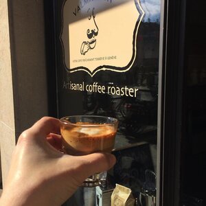 A cappuccino made from Valmandin L'âme de l'artisan gourmet coffee in front of the Valmandin gourmet coffee roaster's shop window.