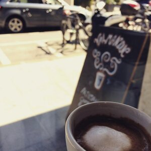 A delicious cup of Valmandin coffee in front of the gourmet coffee roaster's shop window.