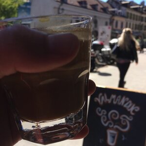 A sunny street view with a freshly brewed and roasted cup of Valmandin coffee in the foreground.